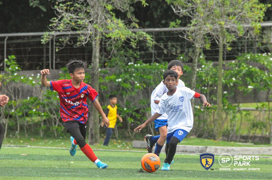 JuniorFam players chasing a football during a match